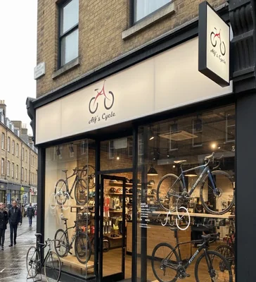 a cycle shop in london where cycle in displayed and a cycle is parked outside